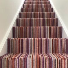 a carpeted staircase leading up to the top floor