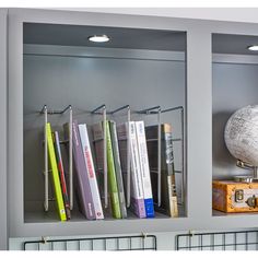 the books are lined up on the shelf in the room with the globe and other items