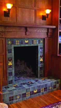 a fireplace in a living room with wood paneling and tile on the mantles