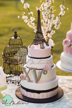 three tiered wedding cake with the eiffel tower in the middle and flowers on top