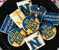 decorated cookies with navy and yellow icing on a black plate