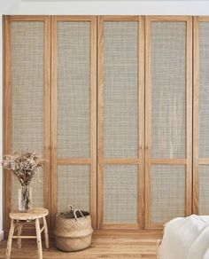 an empty room with wooden doors and white sheets on the floor, next to a small table