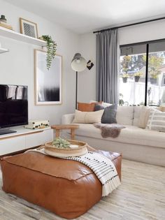 a living room filled with furniture and a flat screen tv on top of a wooden table