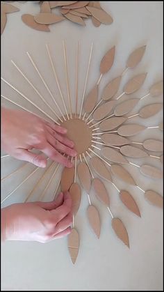 someone is making a paper sunburst out of cardboard and wood dows to make it look like leaves