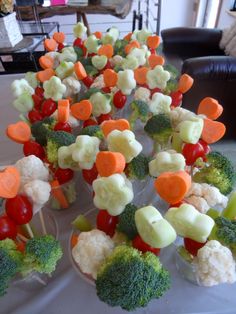 a table topped with lots of veggies on sticks