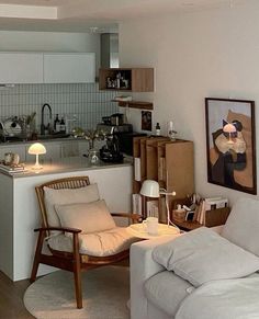 a living room filled with furniture next to a kitchen