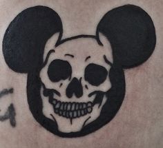 a skull with a mickey mouse head on it's chest is seen in this image