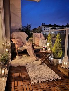 the balcony is decorated with candles, plants and blankets on it's own deck