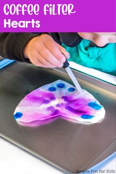 a child is cutting into a piece of art with a knife and some blue dots on it