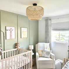 a baby's room with green walls and white furniture