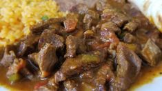 the meal is prepared and ready to be eaten on the plate, including rice and meat