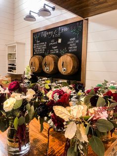 flowers are arranged in vases on a table with a chalkboard behind them that says, mary & erice