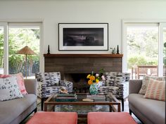 a living room with two couches and a coffee table in front of a fireplace