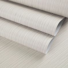 a close up view of a beige wallpaper with thin lines on it and the bottom part of the wall