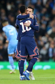 two soccer players hugging each other on the field