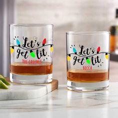 two shot glasses with let's get lit the greens decal on each one