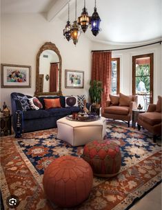 a living room filled with furniture and a chandelier hanging above the couches