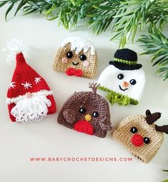 crocheted christmas hats are displayed on a white surface with pine branches in the background