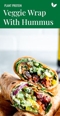 a vegetable wrap with hummus is on a cutting board