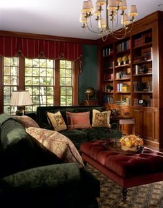 a living room filled with furniture and a chandelier hanging from the ceiling in front of two windows