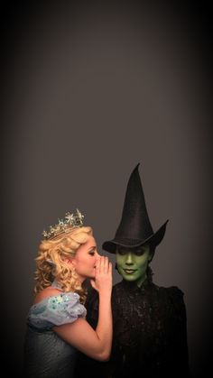 two people dressed up as witches and one is wearing a black hat with her hand on her face