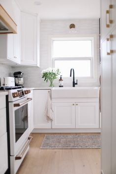 the kitchen is clean and ready for us to use it's white cabinets, counter tops, and appliances