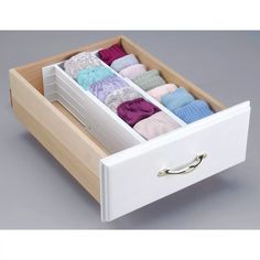 an open drawer with several pairs of socks in it on a gray surface, showing the bottom section