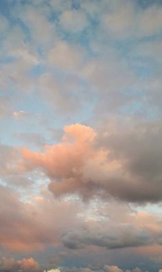 the sky is filled with clouds and there are two kites in the foreground