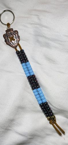 This is a Western Style Keychain with Unique Beads and Concho. This Keychain is made by me here in the USA and is approx 11 inches in length.  This style seems to be making a comeback and I enjoy making them. The idea is to wear these with your keys in your pocket and the concho and beads part is to hang out. This makes it easy to find your keys in your pocket.  I have carried my Keychain for almost 30 years now & it has saved my life twice. I have had to use it in defense of myself 2 times & th Christmas Santa Gifts, Santa Gifts, Christmas Dress, Western Cowboy, Me Time, Western Fashion, Blue Black, Silver Gold, Mens Gifts