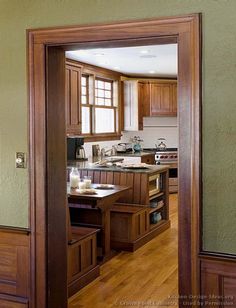 an open door leading to a kitchen with wooden cabinets