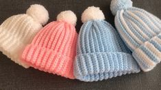 three knitted hats with pom - poms