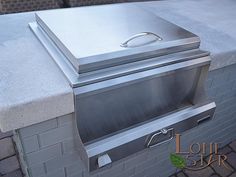 a stainless steel grill sitting on top of a brick patio