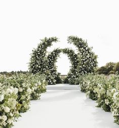 an outdoor ceremony with white flowers and greenery