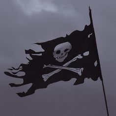 a pirate flag flying in the wind with a skull and crossbones on it