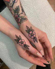 two women with matching tattoos on their hands