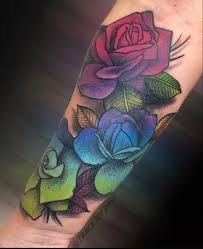 a colorful rose tattoo on the arm