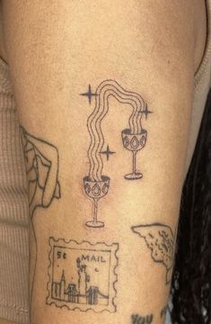 a woman with a tattoo on her arm has a wine glass and map tattooed on it