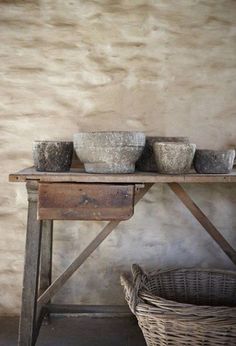 three bowls are sitting on top of a wooden table next to a wicker basket