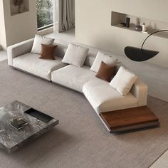 a modern living room with white couches and brown pillows on the floor in front of a large window