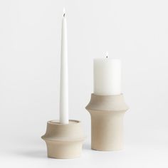 two white candles sitting next to each other