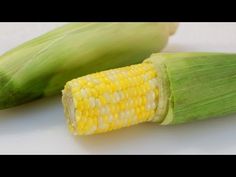 corn on the cob is sitting next to an ear of corn