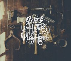 the work hard play hard logo is surrounded by tools and hammers on a wooden surface