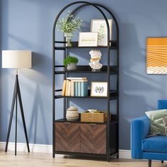 a living room with a blue chair and a book shelf in the corner next to a lamp