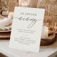 a table topped with plates and candles next to a sign that says in loving memory