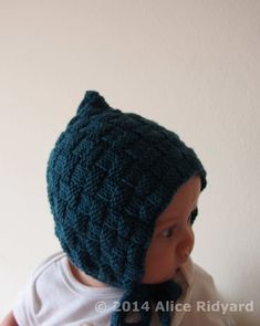 a baby wearing a knitted hat and scarf