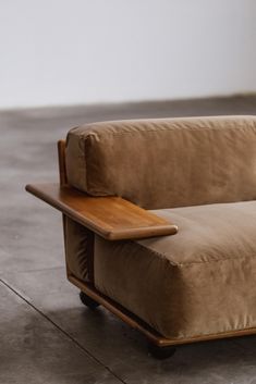 a brown couch sitting on top of a wooden table