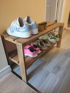 several pairs of shoes are sitting on a wooden shelf