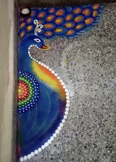 a colorful peacock painted on the ground next to a toilet