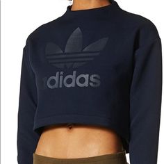 This Versatile Women's Sweatshirt Has A Cropped Cut And Extra-Long Cuffs For An Updated, Urban Silhouette. Made From A Thick Hexagon-Textured Jacquard, It Features A High Neck And Droptail Hem. Finished With A Side Zip On The Neck And Large Trefoil Logo Across The Chest. 100% Polyester Jacquard Rubber-Print Trefoil Logo On Front Ribbed Cuffs Cropped Length With Droptail Hem Zip On Shoulder Blue Adidas Long Sleeve Tops, Adidas Blue Long Sleeve Tops, Adidas Tops With Ribbed Cuffs For Streetwear, Casual Navy Adidas Top, Casual Adidas Tops With Ribbed Cuffs, Adidas Blue Sweatshirt For Fall, Fall Blue Adidas Sweatshirt, Adidas Sweatshirt Women, Rubber Print