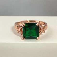 Rose gold plated faux emerald ring, this accessory adds a classic and sparkly touch to your style. The charming rose gold plated ring has cute butterfly and emerald crystal, the color of the birthstone that represents May, a thoughtful detail for this wonderful gift. Material: Cubic Zirconia/Rose Gold Plated/Copper Size: Adjustable ring size 6-9 by yourself, just open and close Stone Size: 9mm x 9mm Smaragd Ring, Rose Gold Plated Ring, Emerald Crystal, Cute Butterfly, Emerald Ring, Ring For Women, Adjustable Rings, Rings Statement, Rose Gold Plates